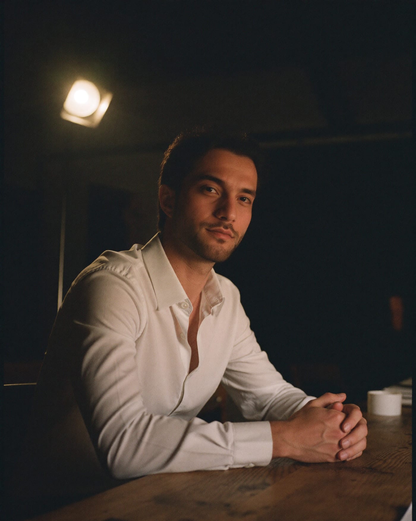 Ali Al-Khafaji — studio portrait, seated at the worktable